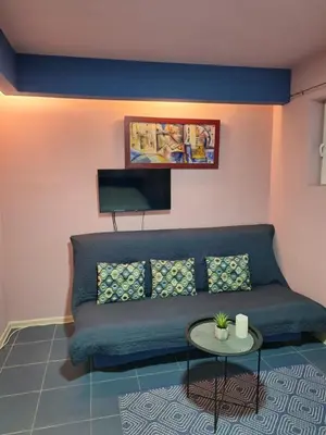 a living room with a blue couch and a table at Dolce Vita in Bukorovac