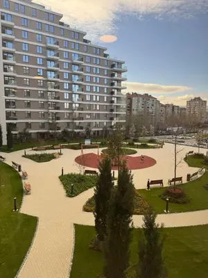 a park with benches and a large building at Palas Central Delux & SPA in Niš
