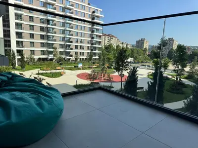 a balcony with a large window with a view of a city at Palas Central Delux & SPA in Niš