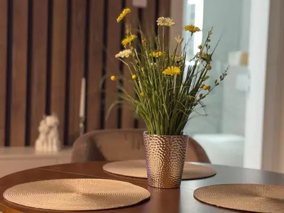 a vase of flowers sitting on top of a table at Palas Central Delux & SPA in Niš
