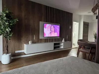 a living room with a flat screen tv on a wall at Palas Central Delux & SPA in Niš