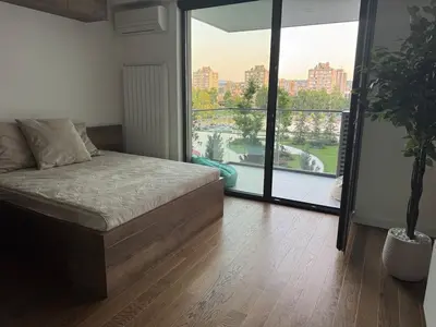a bedroom with a bed and a large window at Palas Central Delux & SPA in Niš