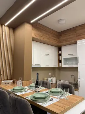 a dining room table with plates and wine glasses at Apartman Kristal, Vrnjačka Banja in Vrnjci