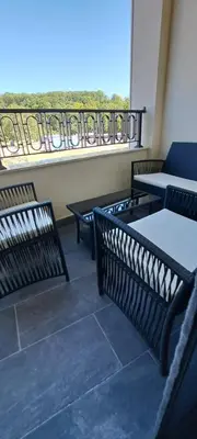a balcony with tables and chairs and a view of a balcony at Apartman Kristal, Vrnjačka Banja in Vrnjci