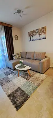 a living room with a couch and a table at Apartman Kristal, Vrnjačka Banja in Vrnjci