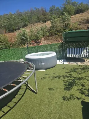 a bath tub sitting on the grass next to a table at Yellow hill Batinac in Ćuprija
