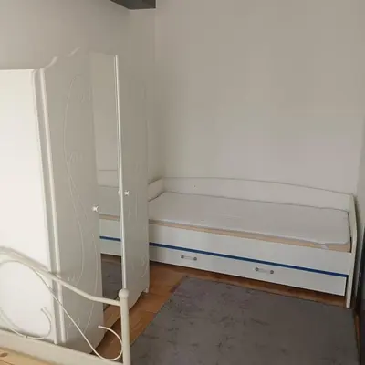 a small bedroom with a bed and a cabinet at Zora in Niš