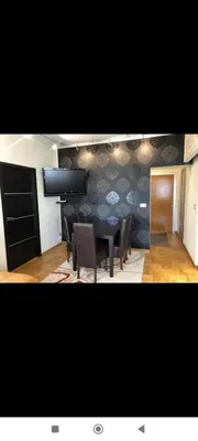 a dining room with a table and chairs and a wall at Zora in Niš