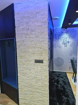a brick wall in a room with a chair at POSEJDON DELUXe 3 in Vrnjačka Banja