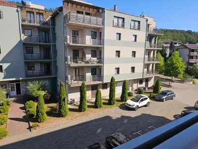 an apartment building with cars parked in a parking lot at POSEJDON DELUXe 3 in Vrnjačka Banja
