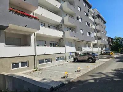 a car parked in a parking lot in front of a building at POSEJDON DELUXe 3 in Vrnjačka Banja