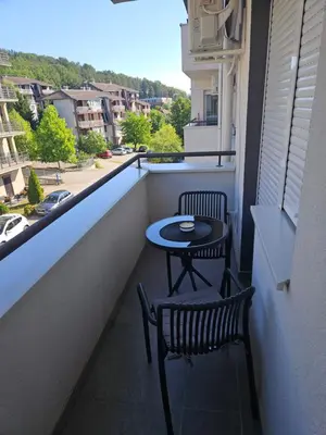a balcony with two chairs and a table on it at POSEJDON DELUXe 3 in Vrnjačka Banja
