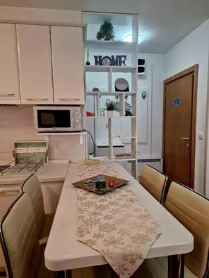 a kitchen with a table and chairs in a room at Zlatibor studio Lilly in Bukorovac