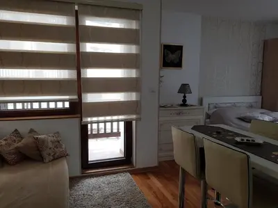 a bedroom with a bed and a window with blinds at Zlatibor studio Lilly in Bukorovac