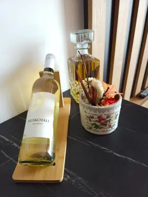 a bottle of whiskey and a bowl of flowers on a table at Una LUX N85 in Kopaonik