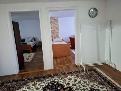 a room with a bedroom and a bed and a mirror at Home Well Apartman Vranje in Vranje