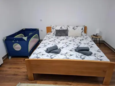 a bed with two pillows on it in a bedroom at Home Well Apartman Vranje in Vranje