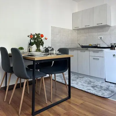 a kitchen with a wooden table with chairs and a counter at Stan na dan Raška in Raška
