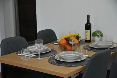 a table with a bowl of fruit and a bottle of wine at Stan na dan Raška in Raška