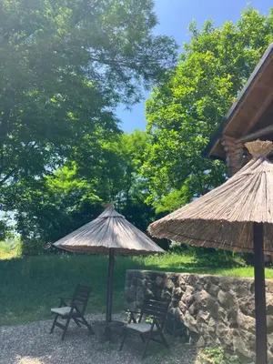 two straw umbrellas and two chairs and a table at Semeteška bajka in Raška