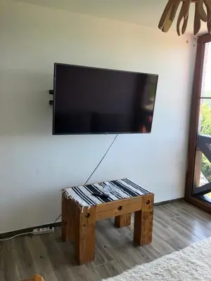 a living room with a table and a flat screen tv at Semeteška bajka in Raška