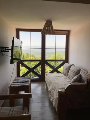 a living room with a couch and a large window at Semeteška bajka in Raška