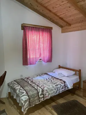 a bed in a room with a red window at Semeteška bajka in Raška