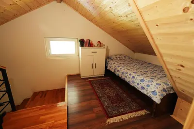 a small bedroom with a bed in a attic at Mladenović Kuća in Kopaonik