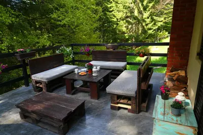a patio with two chairs and a table and benches at Mladenović Kuća in Kopaonik