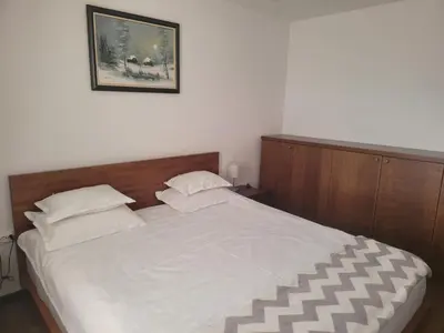 a bedroom with a large white bed with two pillows at Zoi i Nika Kopaonik in Kopaonik