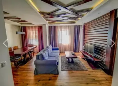 a living room with a blue couch and a television at Zoi i Nika Kopaonik in Kopaonik