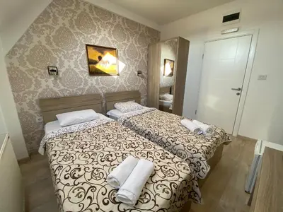 a bedroom with a bed with towels on it at Hotel Zeleni Vir in Niš