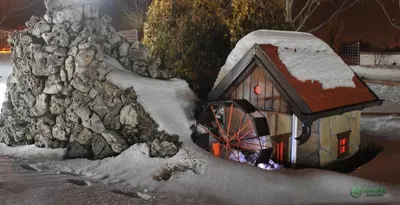 a snow covered house and a stone wall at Hotel Zeleni Vir in Niš