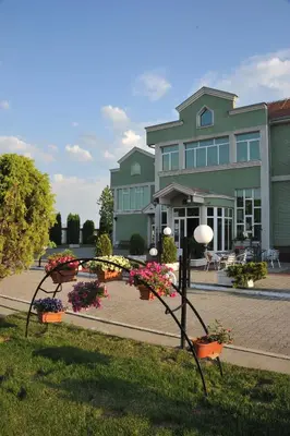 a large building with flowers in front of it at Hotel Zeleni Vir in Niš