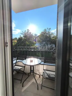 a patio with a table and chairs on a balcony at Apartman Vujanac in Vrnjačka Banja