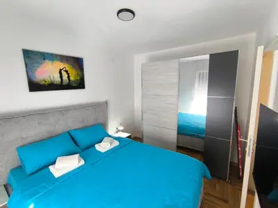 a bedroom with a blue bed and a window at Apartman Vujanac in Vrnjačka Banja