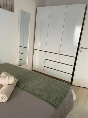 a bedroom with a bed and a large white cabinet at Udoban kutak 2 in Niš
