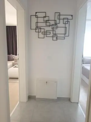 a room with a white wall with a mirror at Udoban kutak 2 in Niš