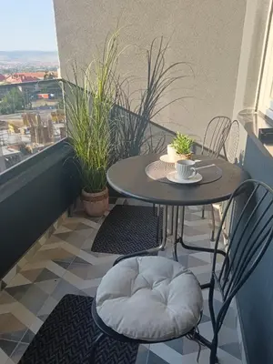 a small table and chairs on a balcony at Udoban kutak 2 in Niš