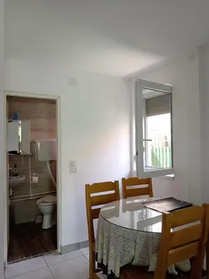 a dining room with a table and chairs and a bathroom at Smeštaj Golubica 1 in Soko Banja