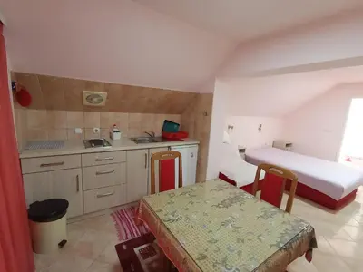 a small kitchen with a bed and a table in a room at Smeštaj Golubica 4 in Soko Banja