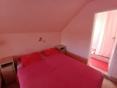 a bedroom with a red bed with two red pillows at Smeštaj Golubica 4 in Soko Banja