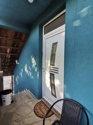 a door with a chair in front of a building at Apartman Pače in Raška