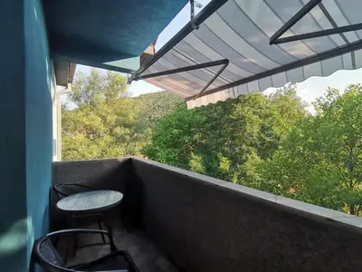 a balcony with two chairs and a table and a window at Apartman Pače in Raška