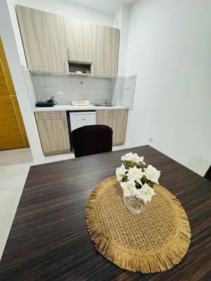 a dining room table with a vase of flowers on it at Aqua Apartments 3 in Jagodina