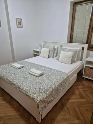 a bedroom with a large white bed with pillows at Toplica in Vrnjačka Banja