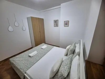 a bedroom with a bed with white sheets and pillows at Toplica in Vrnjačka Banja