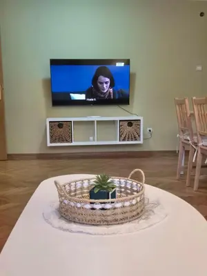 a living room with a tv and a table with a cake at Toplica in Vrnjačka Banja
