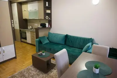 a living room with a green couch and a table at Apartman Stefan Vrnjacka Banja in Vrnjačka Banja