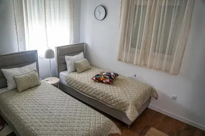a bedroom with two beds and a clock on the wall at Kuća Petrovića in Aleksandrovac